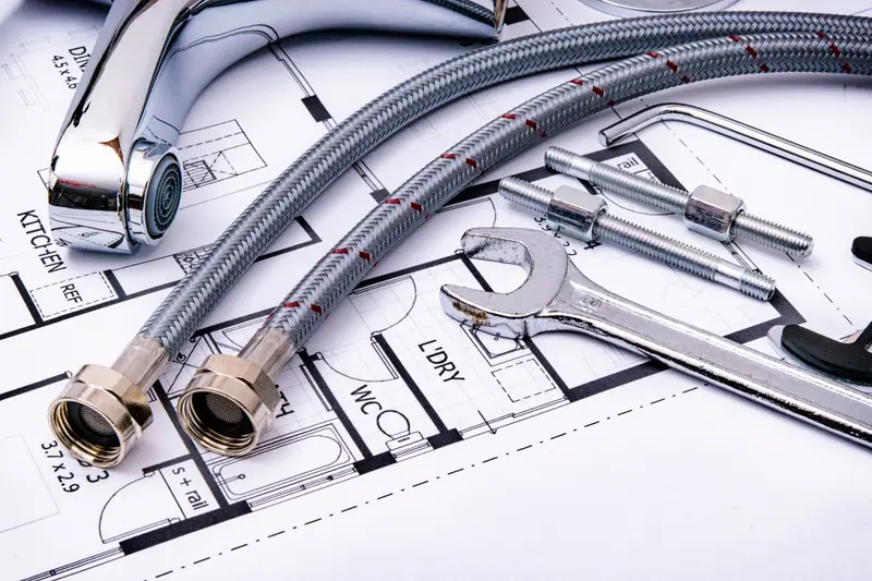 Flexibele aansluitslangen, een kraan en een steeksleutel op een installatietekening